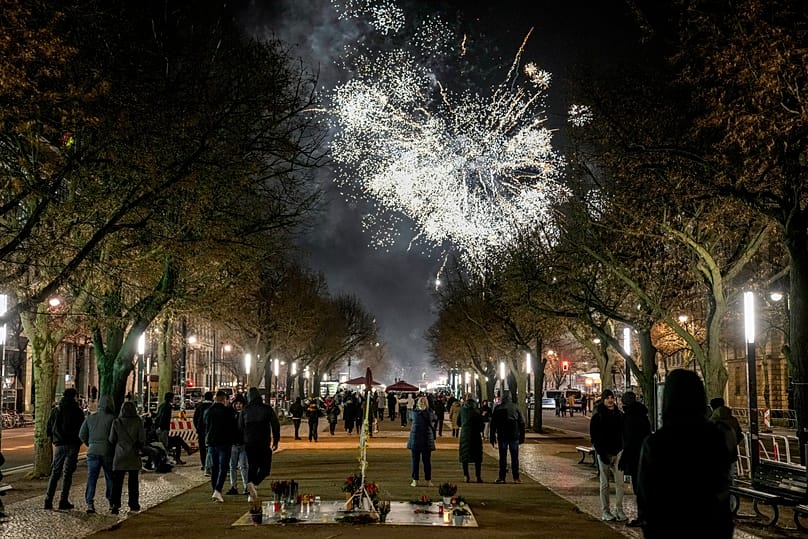 People gather near the Brandenburg Gate to celebrate and watch the fireworks for the New Year's celebrations in Berlin, 31 December, 2024