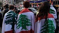 شبان يلفّون أنفسهم بالأعلام اللبنانية