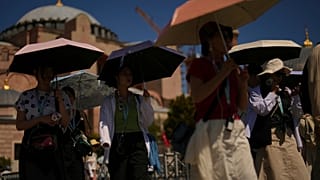 Turisták napernyőkkel védik magukat a naptól a Hagia Sophia mecset előtt egy forró nyári napon Isztambulban, 2025. augusztus 12-én.