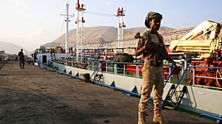 في هذه الصورة التي التُقطت يوم الخميس 29 نوفمبر 2018، يقف مسلحون يمنيون على الحراسة في ميناء المكلا، اليمن. وتُظهر مدينة المكلا الساحلية