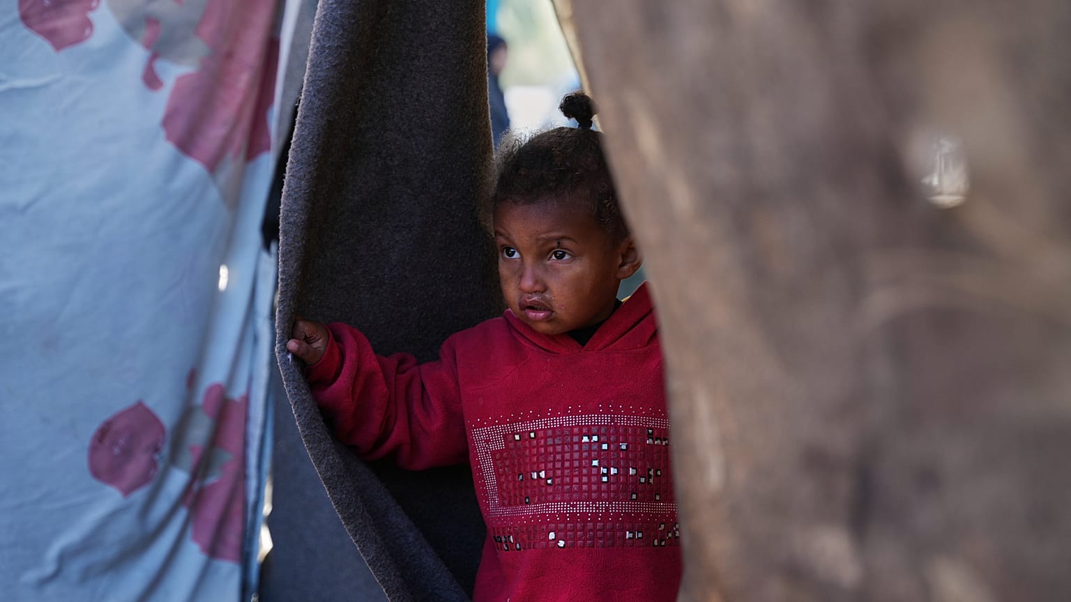 طفلة في مخيم مؤقت للنازحين الفلسطينيين في دير البلح، وسط قطاع غزة، يوم السبت 27 كانون الأول/ديسمبر 2025.