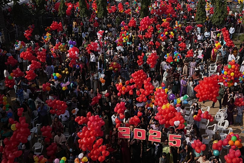 Indian Christians celebrate the New Year after offering prayers at a Church in Ahmedabad, 1 January, 2025
