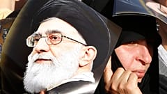 امرأة من أنصار حزب الله تحمل ملصقًا للمرشد الأعلى الإيراني، الخميس 14 تشرين الأول/أكتوبر 2010.
