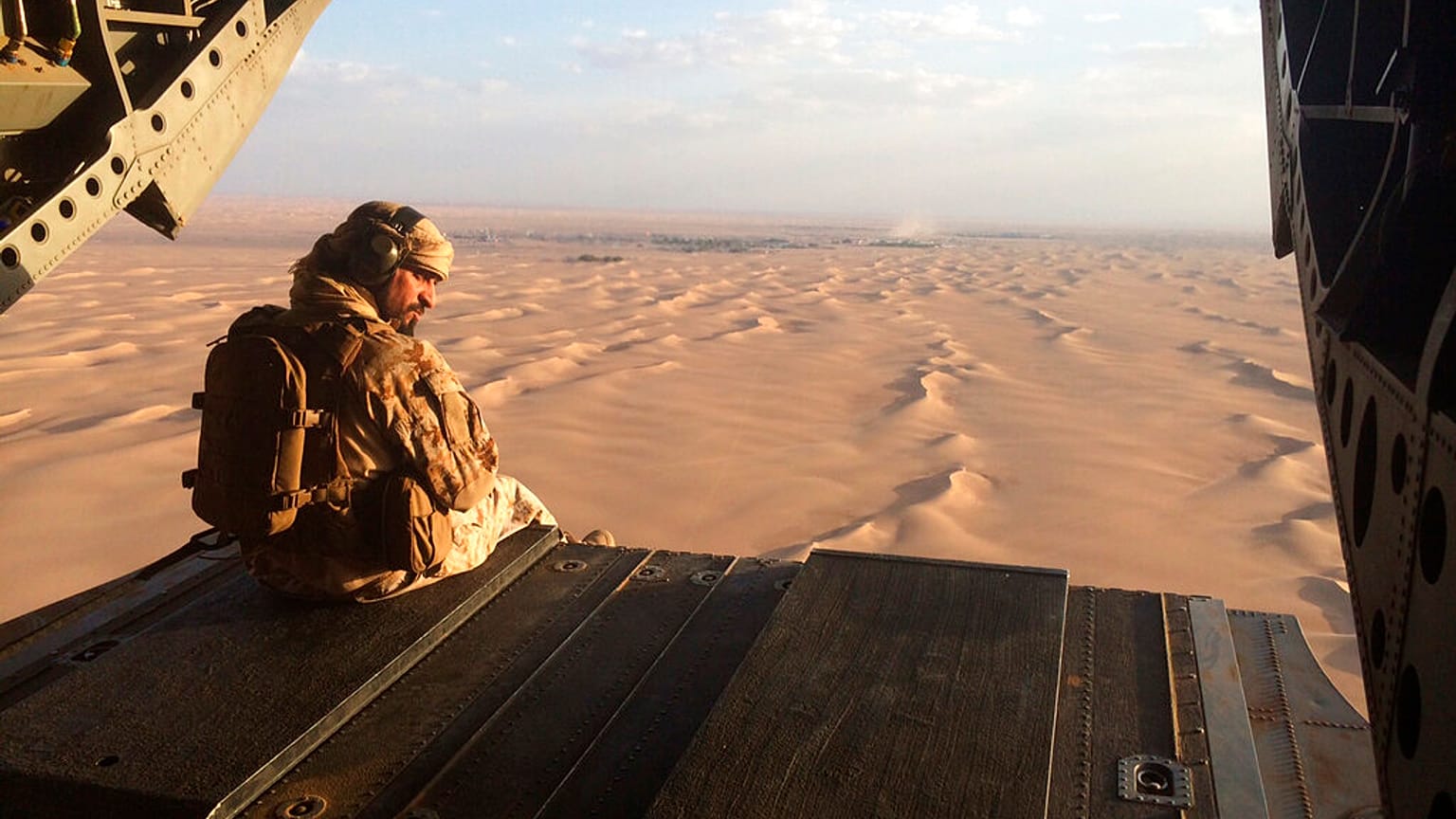 في هذه الصورة المؤرخة 17 سبتمبر 2015، يراقب جندي إماراتي إطلاق النار من البوابة الخلفية لمروحية عسكرية إماراتية من طراز تشينوك تحلق فوق اليمن