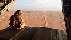 في هذه الصورة المؤرخة 17 سبتمبر 2015، يراقب جندي إماراتي إطلاق النار من البوابة الخلفية لمروحية عسكرية إماراتية من طراز تشينوك تحلق فوق اليمن