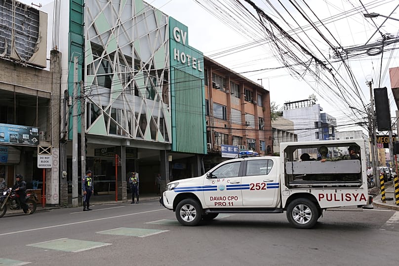 A police vehicle passes by a budget hotel in downtown Davao City, southern Philippines where Bondi beach suspects reportedly stayed while in the country, 17 December 2025