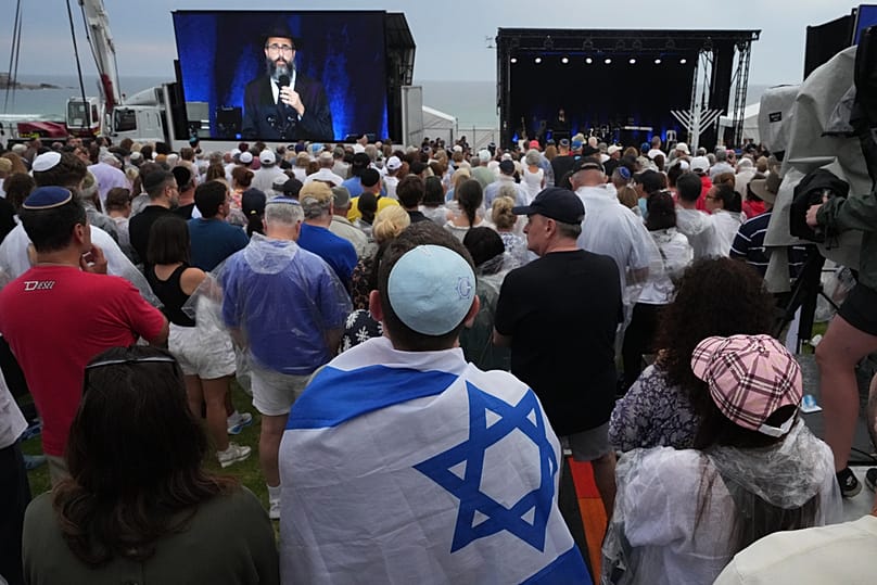 People attend a ceremony to mark the National Day of Reflection for victims and survivors, at Bondi Beach in Sydney, 21 December 2025
