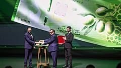 O presidente sírio Ahmed al-Sharaa, à esquerda, e Abdul Qader Hosriya, governador do Banco Central da Síria, exibem uma nota durante uma cerimônia de lançamento da nova moeda 