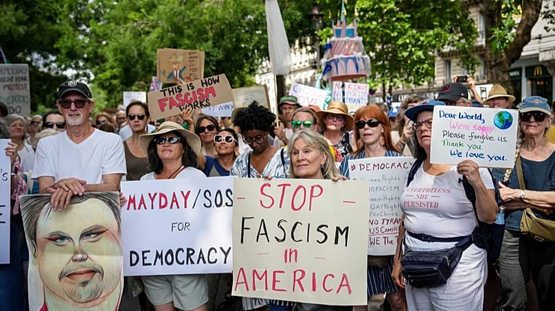 Teilnehmer der "No Kings"-Proteste mit Transparenten in Paris (14. Juni 2025).
