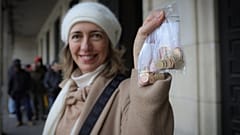 امرأة تلتقط صورة وهي تمسك بعملات يورو جديدة تحمل رموزًا بلغارية في صوفيا أمام البنك الوطني البلغاري، السبت 27 ديسمبر 2025