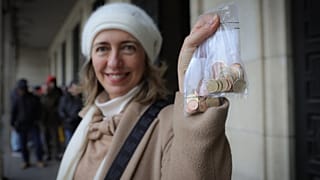 امرأة تلتقط صورة وهي تمسك بعملات يورو جديدة تحمل رموزًا بلغارية في صوفيا أمام البنك الوطني البلغاري، السبت 27 ديسمبر 2025