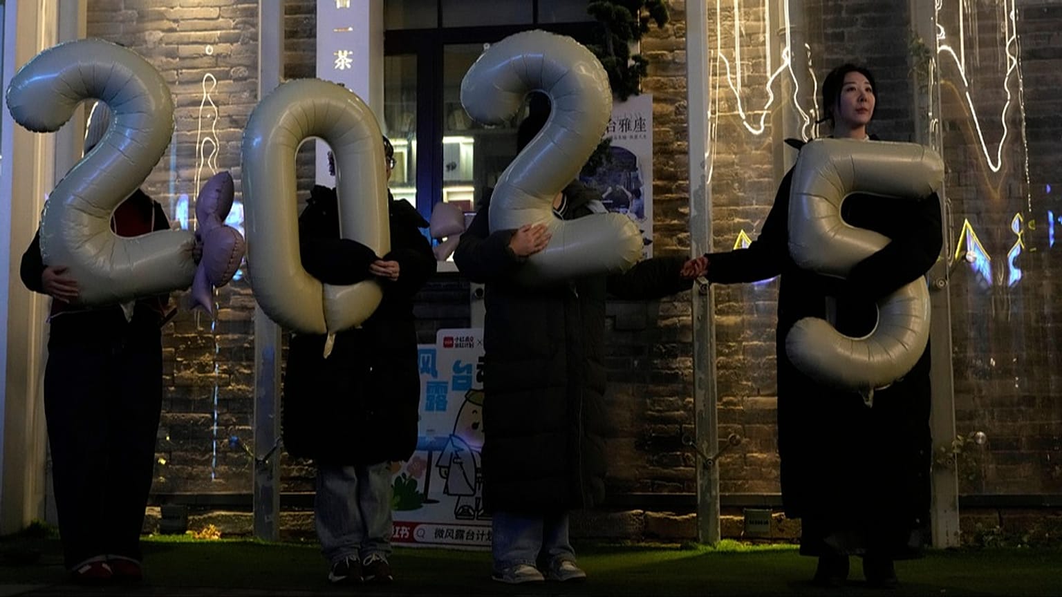 FILE - Workers hold up balloons showing 2025 as they shoot a video to welcome 2026 at a shopping district in Beijing, China, Thursday, Dec. 18, 2025. (AP Photo/Ng Han Guan)