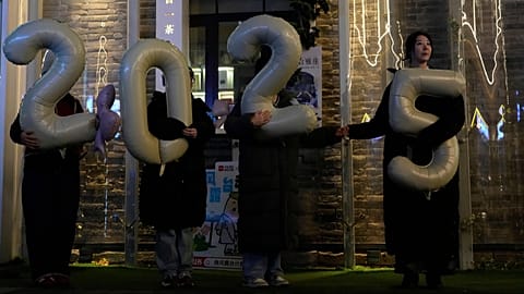 FILE - Workers hold up balloons showing 2025 as they shoot a video to welcome 2026 at a shopping district in Beijing, China, Thursday, Dec. 18, 2025. (AP Photo/Ng Han Guan)