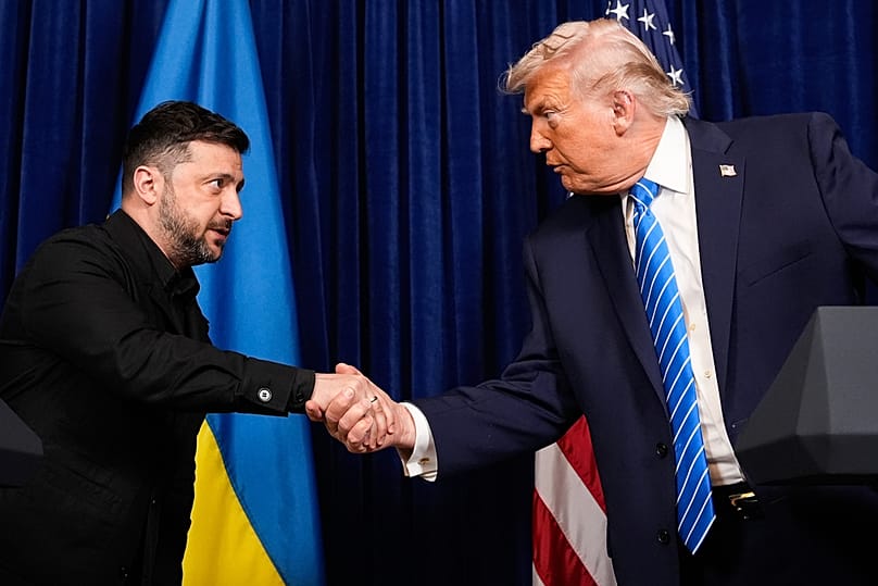 US President Donald Trump and Ukraine's President Volodymyr Zelenskyy shake hands at the start of a joint news conference following a meeting at Mar-a-Lago, 26 December 2025