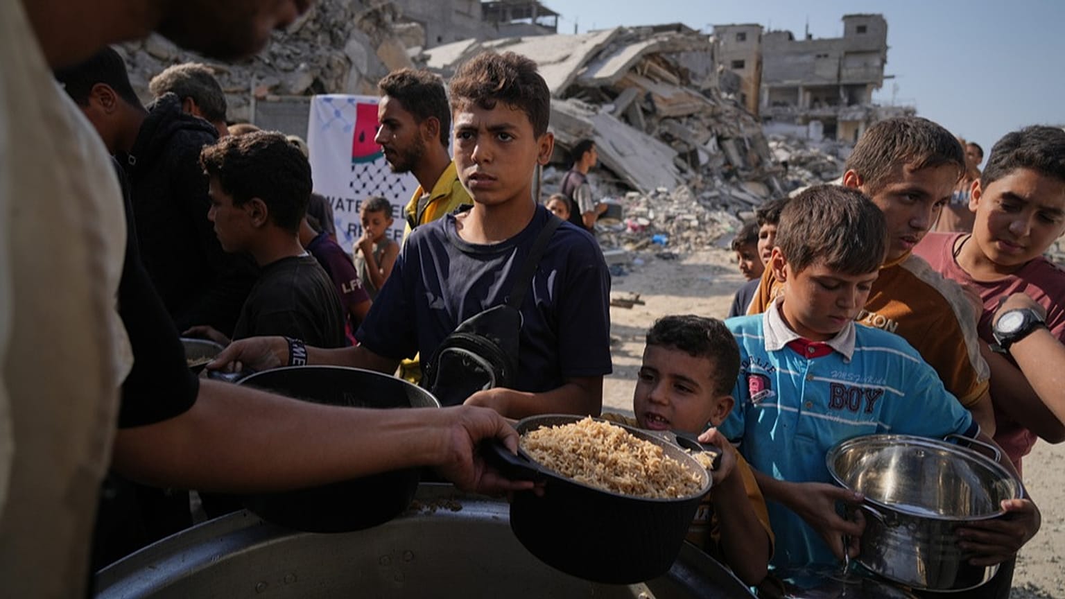 فلسطينيون يتسلّمون وجبات غذائية في مطبخ مجتمعي بمدينة غزة، الخميس، أكتوبر 2025.