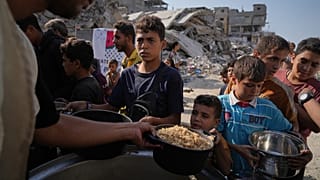 فلسطينيون يتسلّمون وجبات غذائية في مطبخ مجتمعي بمدينة غزة، الخميس، أكتوبر 2025.