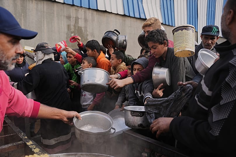 فلسطينيون يكافحون للحصول على طعام في مطبخ مجتمعي بمخيم النصيرات وسط قطاع غزة، في 17 ديسمبر 2025.