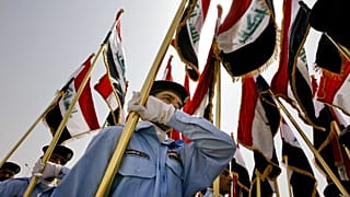  استعرضت قوات الأمن العراقية حاملةً الأعلام العراقية خلال مراسم تسليم السلطة في مقر الحكومة بالرمادي، عاصمة محافظة الأنبار، يوم الاثنين 1 سبتمبر/أيلول 2008.