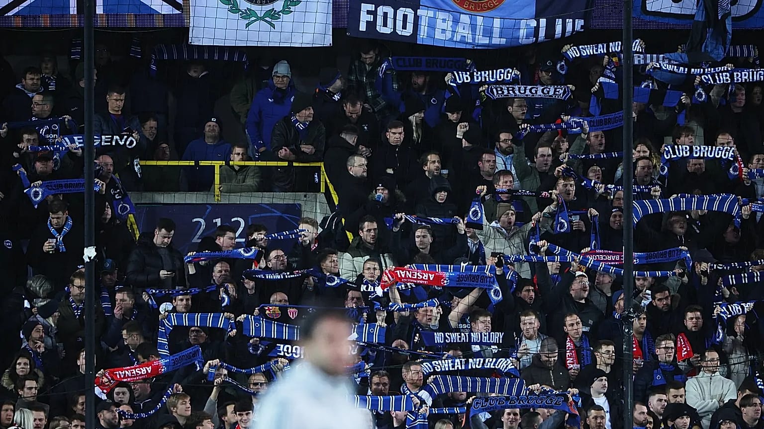 Fans hold up scarves to support their teams prior to the Champions League opening phase match between Club Brugge and Arsenal in Bruges, 10 December, 2025