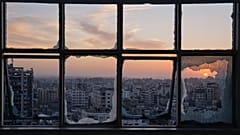 تغرب الشمس خلف مبانٍ متضررة جراء الحرب في مدينة غزة، الأربعاء، 31 ديسمبر/كانون الأول 2025.