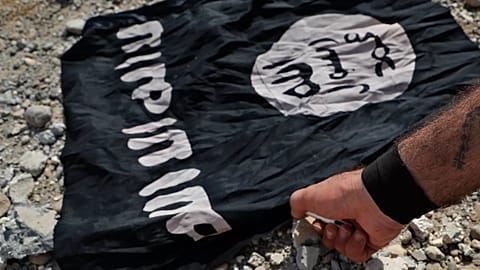 Bir milis savaşçı Rakka'nın batı yakasındaki cephe hattında bir İD bayrağını yakıyor, 17 Temmuz 2017