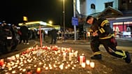 People lay candles and flowers near the Le Constellation bar where a devastating fire left dead and injured during the New Year's celebrations in Crans-Montana, 1 January 2025