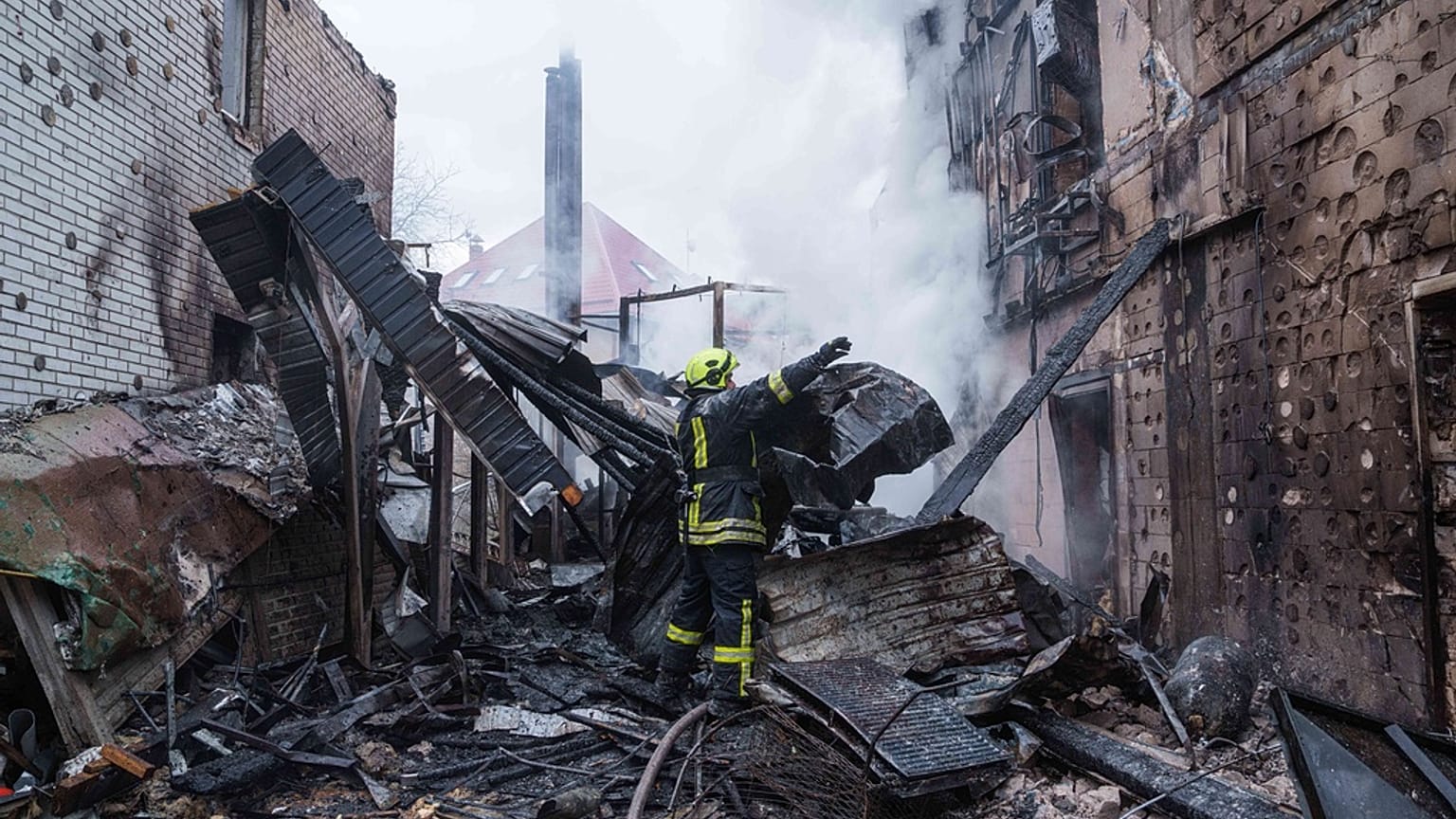 عامل إنقاذ يزيل أنقاض منزل دمّرته ضربة روسية على كييف في 27 ديسمبر 2025.