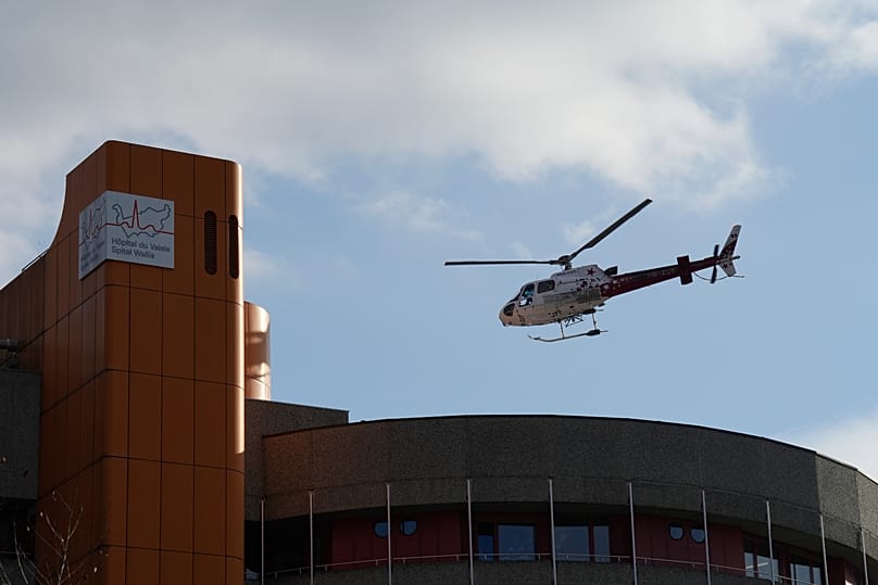 Ein Rettungshubschrauber bringt Schwerverletzte nach dem Brand in Crans-Montana in ein Krankenhaus - die Kliniken der Region arbeiten am Limit.