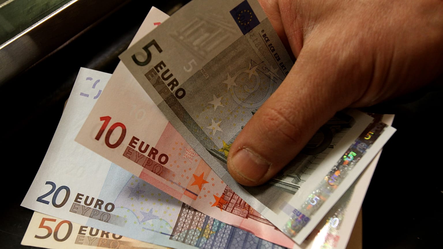 Ein Mann erhält Euronoten, Athen, Griechenland, 8. April 2010