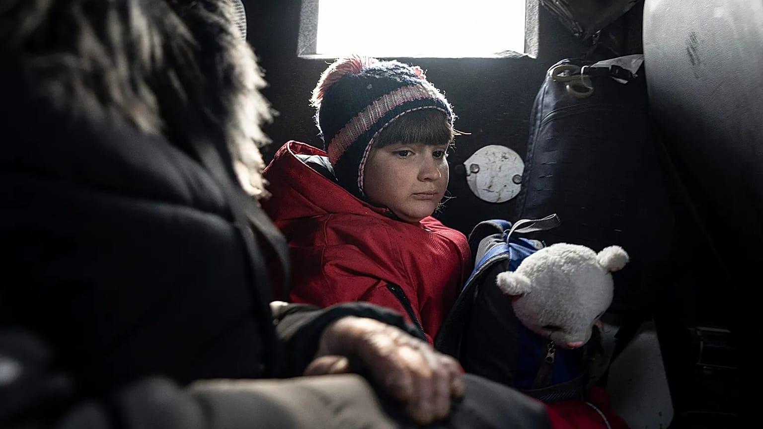 A girl rides with her mother inside a van during an evacuation by Ukrainian police in Avdiivka, 7 March, 2023