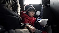 Ein Mädchen fährt mit seiner Mutter in einem Lieferwagen während einer Evakuierung durch die ukrainische Polizei in Avdiivka, 7. März 2023