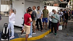 Vor einem Supermarkt in Caracas, Venezuela, stehen am Samstag, dem dritten Januar 2026, Menschen Schlange.