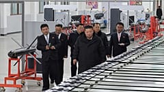 Az észak-koreai kormány által biztosított fotón Kim Dzsongun, az ország vezetője (jobbra elöl) egy ismeretlen helyen található nagy lőszergyárat látogat meg Észak-Koreában, s