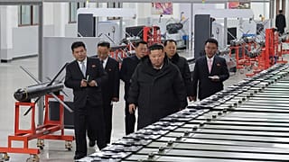 Az észak-koreai kormány által biztosított fotón Kim Dzsongun, az ország vezetője (jobbra elöl) egy ismeretlen helyen található nagy lőszergyárat látogat meg Észak-Koreában, s