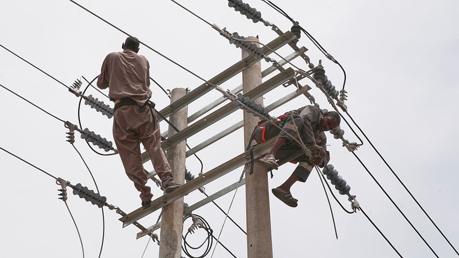  عمال يصلحون كابلات الكهرباء التي دُمرت سابقاً خلال القتال بين القوات المسلحة السودانية وقوات الدعم السريع شبه العسكرية، في الخرطوم، السودان، يوم الاثنين 18 أغسطس/آب 2025.