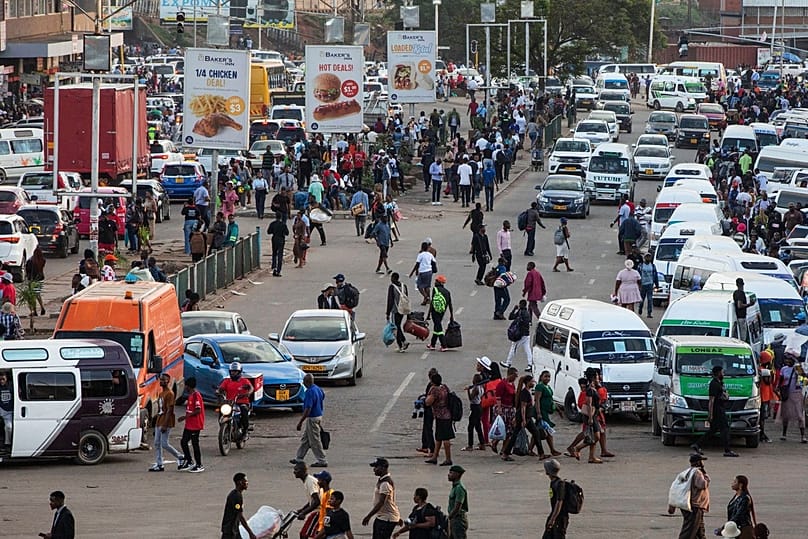 An overview of commuters at a minibus taxi area during rush hour in downtown Harare, Zimbabwe, Tuesday, Dec. 16, 2025