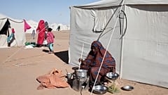 امرأة سودانية نازحة من الفاشر تطبخ خارج خيمتها في المخيم الجديد الأفاضل بمدينة الدبة بولاية شمال السودان، يوم الأحد 16 نوفمبر 2025.