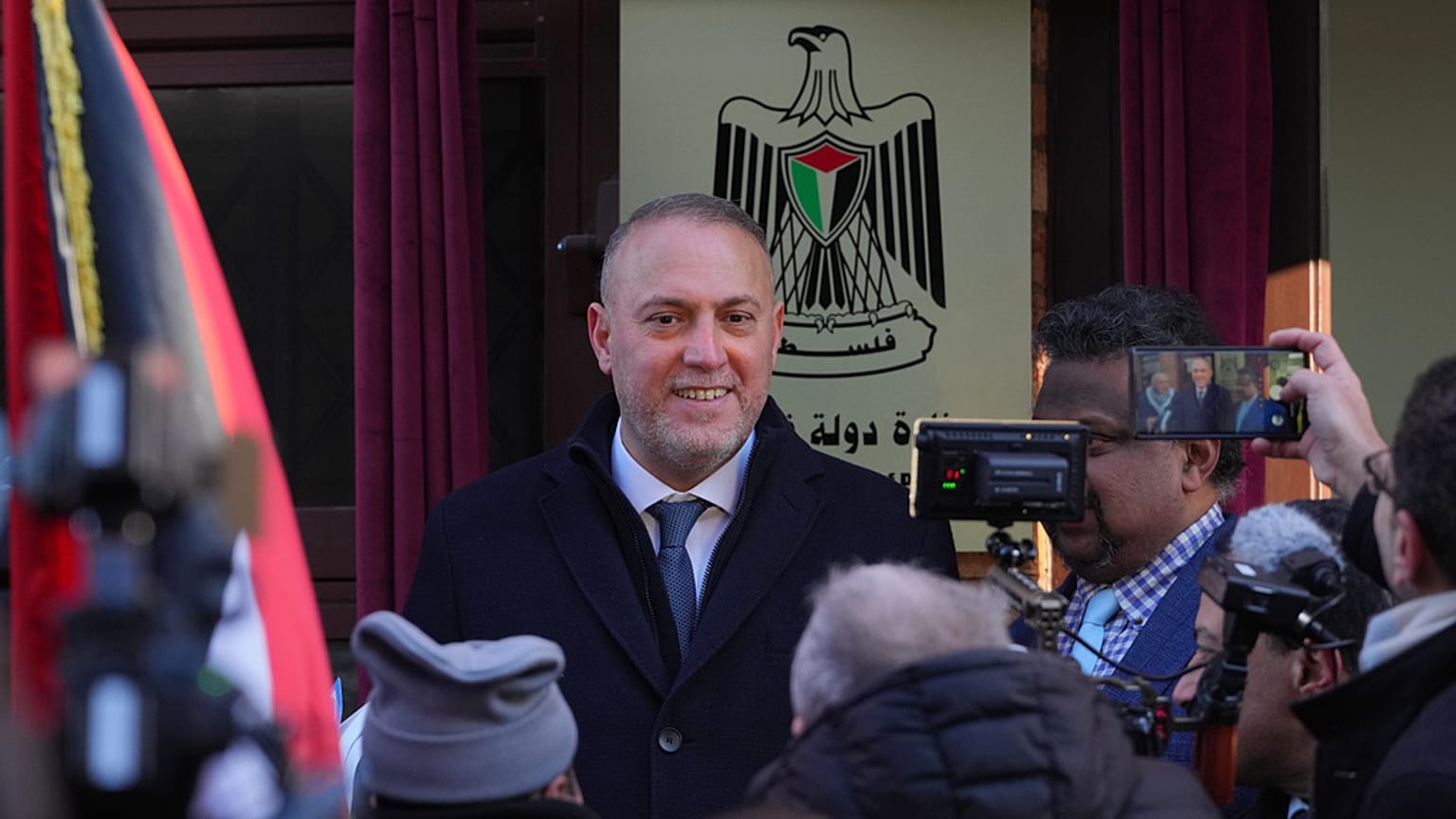 يقف حسام زملط، رئيس البعثة الفلسطينية في المملكة المتحدة، حاملاً اللوحة التذكارية في حفل افتتاح السفارة الفلسطينية في لندن، يوم الاثنين 5 يناير/كانون الثاني 2026.