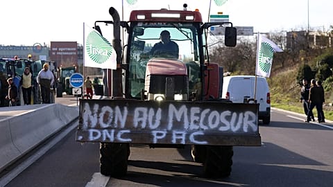 A French farmer drives his tractor to block a main road during a protest against the Mercosur trade deal with South American nations, December 2025