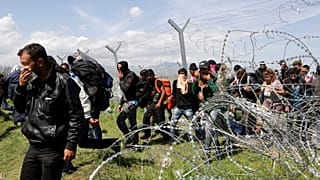 Migrants walk to a registration and transit camp after entering Macedonia from Greece near the southern Macedonian town of Gevgelija, Sunday, March 6, 2016. 