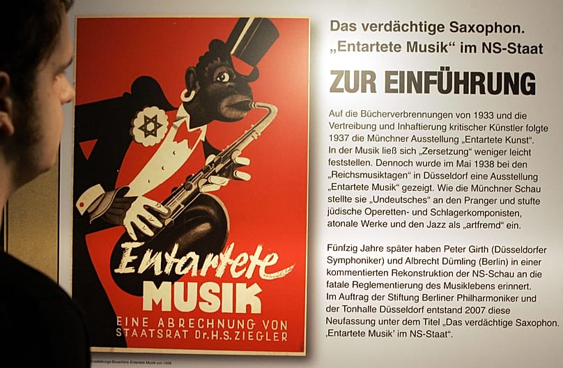 Ein Mann blickt am Freitag, 2. November 2007, in der Berliner Philharmonie in Berlin auf ein Poster einer Ausstellungsbroschuere von 1938. 