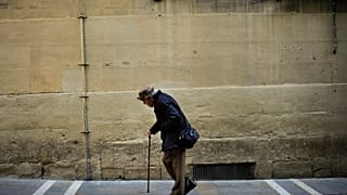 رجل مسنّ يخرج في نزهة مستعينًا بعكاز، في مدينة بامبلونا شمال إسبانيا، يوم الأربعاء 22 مايو/أيار 2013.