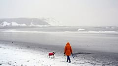 In Scarborough an Englands Nordseeküste führt eine Person einen Hund aus.