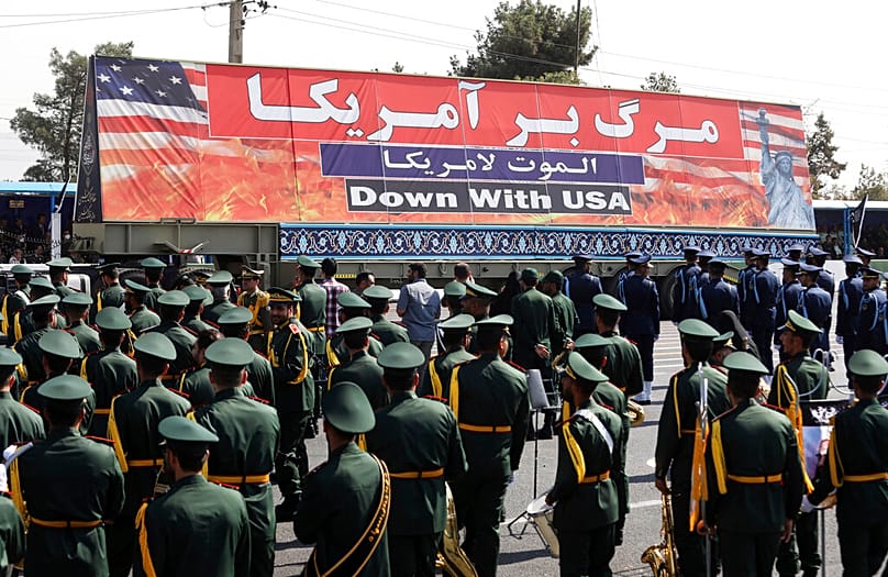 FILE - An anti-U.S banner is carried on a truck during a military parade commemorating the anniversary of the start of the 1980-88 Iraq-Iran war.