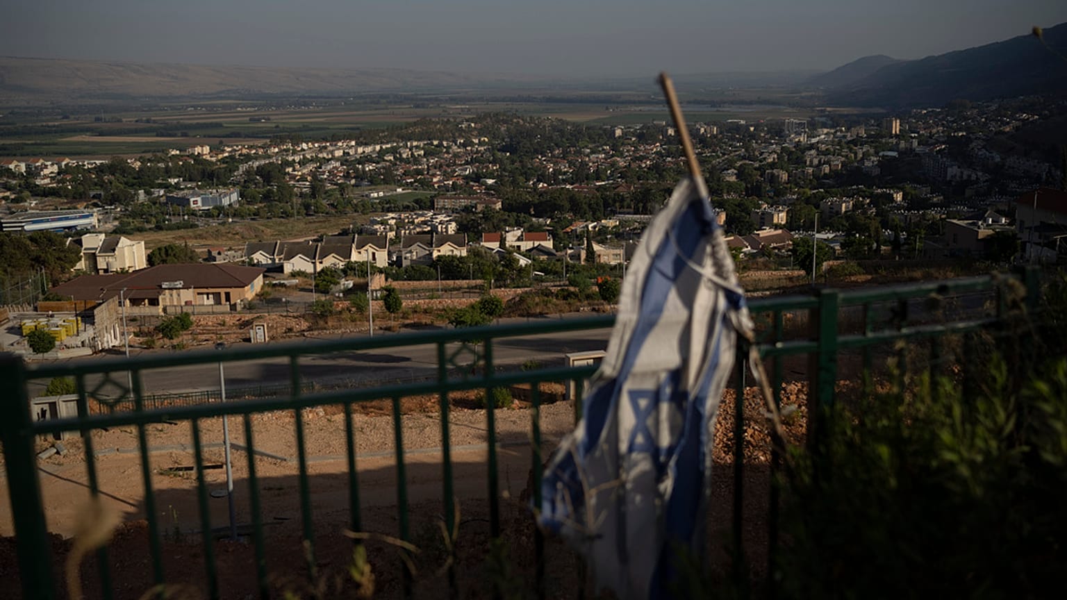 يرفرف علم إسرائيل في منطقة تحيط بها المباني في كريات شمونة، المدينة المتاخمة للحدود مع لبنان، شمال إسرائيل