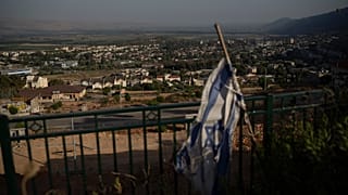 يرفرف علم إسرائيل في منطقة تحيط بها المباني في كريات شمونة، المدينة المتاخمة للحدود مع لبنان، شمال إسرائيل