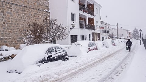 ARCHIVO: Un hombre camina bajo una fuerte nevada en Bustarviejo, en las afueras de Madrid, España, el sábado 9 de enero de 2021.