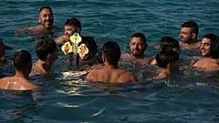 Peregrino apanha a cruz lançada à água por um padre ortodoxo durante cerimónia da Epifania para abençoar o mar na aldeia de Xylophagou, no sudeste de Chipre