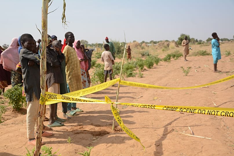 People stand behind crime scene tape at the site of a US airstrike in Jabo, 26 December, 2025