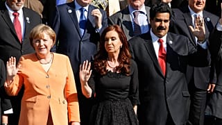 Angela Merkel e Nicolas Maduro acenam durante um evento político.